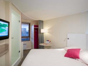 a hotel room with a bed and a flat screen tv at ibis Styles Lille Centre Gare Beffroi in Lille +50 photos