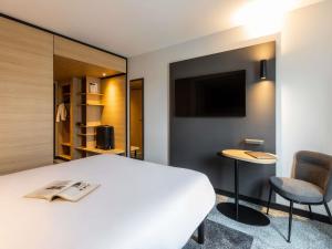 a hotel room with a bed and a tv at ibis Nancy Centre Stanislas in Nancy
