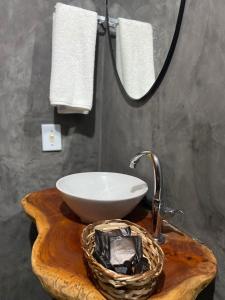 a bathroom with a sink and a bowl on a wooden table at Pousada Villa Uçá Frances - Praia do Frances in Praia do Frances