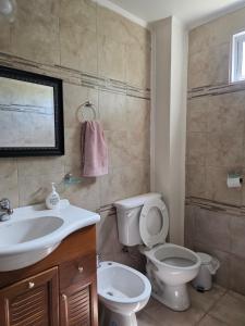 Un baño con un inodoro blanco y un lavabo. en Timotea, en Perito Moreno