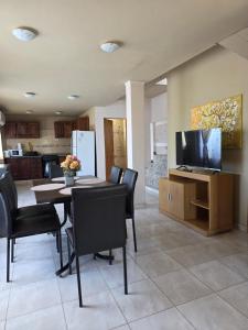Un comedor con mesa y sillas y un televisor. en Timotea, en Perito Moreno