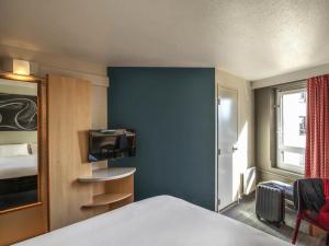 a bedroom with a bed and a blue wall at ibis Tours Centre Gare in Tours