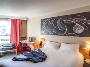 a bedroom with a bed and a desk with a computer at ibis Tours Centre Gare in Tours