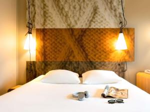 a hotel room with a bed with sunglasses on it at ibis Leuven Centrum in Leuven +45 photos