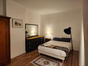 ein Schlafzimmer mit einem Bett, einer Kommode und einem Spiegel in der Unterkunft Évasion Parisienne exelmans et Tour Eiffel in Paris