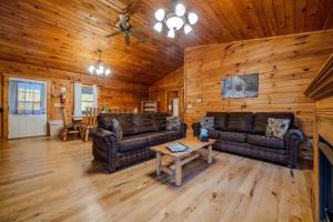 ein Wohnzimmer mit Ledersofas und einem Tisch in der Unterkunft Secluded Log Cabin with a Hot Tub near Bridle Trails in Logan, Ohio in Cedar Grove