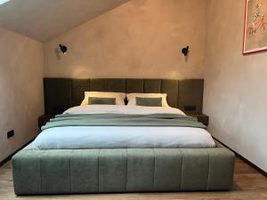 ein Bett mit einer grünen Ottomane in einem Schlafzimmer in der Unterkunft Imperial Residence - design aparthotel in city center, private parking in Banská Bystrica + 97 Fotos