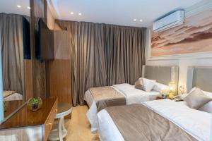a hotel room with two beds and a desk at lotus view El tahrir in Cairo