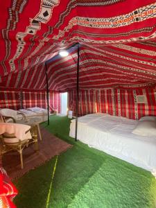 BadīyahSky Window Camp的一间卧室配有天蓬床和桌椅