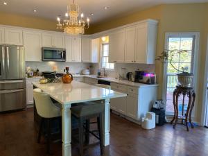 a kitchen with white cabinets and a table with chairs at Suite in Lakeside house in Alpharetta