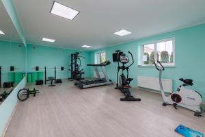 a gym with several treadmills and machines in a room at Вілла "Синевір" in Skhidnitsa