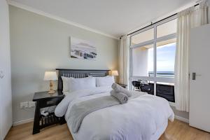 a bedroom with two beds and a large window at Atlantic Haven in Bloubergstrand +35 photos