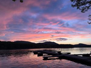a sunset on a lake with a dock at The Inn At The Bridge in Northville