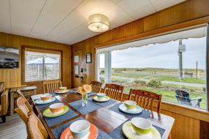 a dining room with a table and chairs and a large window at Beachfront Cottage on Seaside Promenade with Hot Tub in Seaside