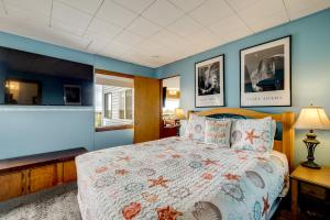 a bedroom with a large bed with blue walls at Beachfront Cottage on Seaside Promenade with Hot Tub in Seaside
