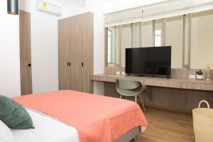 una camera da letto con un letto e una TV a schermo piatto di Casa del Viento 102 a Cali