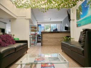 a living room with two couches and a glass table at Hotel Jardin de Laureles Jeps in Medellín