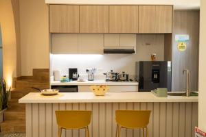 una cucina con bancone e 2 sedie gialle di Casa del Viento 102 a Cali