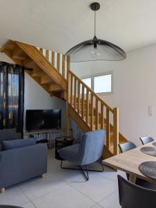 a living room with a staircase and a table and chairs at Le jamerosas in Le Tampon
