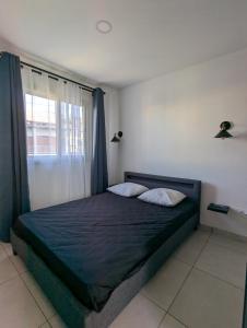 a bedroom with a large bed with a window at Le jamerosas in Le Tampon