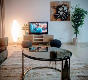 a living room with a coffee table and a tv at 3 bedrooms apartment in Al Rehab city in New cairo