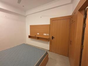 Un dormitorio con una cama y una puerta de madera. en Awadh Savitri Homestay, en Faizābād 2 fotos más