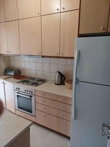 eine Küche mit Kühlschrank und Herd in der Unterkunft Sea and City Voula Suite by First Class Properties in Athen