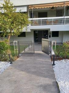 ein Gehweg vor einem Gebäude mit einem Zaun in der Unterkunft Sea and City Voula Suite by First Class Properties in Athen