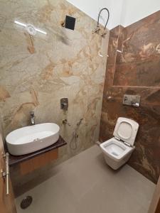 Un baño con un inodoro blanco y un lavabo. en Awadh Savitri Homestay, en Faizābād