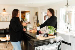 a man and woman standing in a kitchen with a bottle of wine at Woody Mountain Bed & Breakfast in Flagstaff