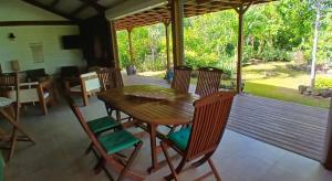 a dining room with a wooden table and chairs at Villa Ti Colibri in Bouillante