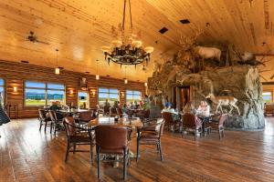 a restaurant with people sitting at tables in front of a stone wall at Bar N Ranch in West Yellowstone