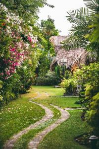 a gravel path in a garden with flowers at Kariwak Wellness Village, Hotel and Holistic Haven in Crown Point