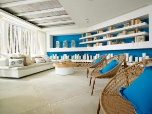 a living room with blue walls and wicker chairs at Artemis Seaside Resort in Paliochori