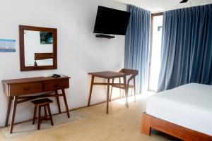 Un dormitorio con una cama, un escritorio y un espejo. en Hotel Casa Tortuga Tulum - Cenotes Park Inclusive, en Tulum