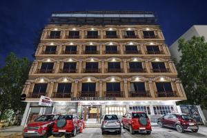 a building with cars parked in front of it at Townhouse OAK Hotel Belsons Taj Mahal in Hyderabad
