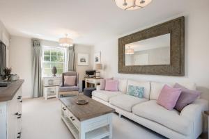 a living room with a white couch and a mirror at Pass the Keys Former Show Home 6 min walk to Deddington in Deddington