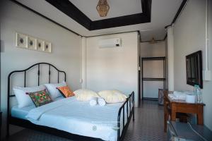 a bedroom with a bed with blue sheets and pillows at คลองมาดโฮสเทลเกาะกูด Klongmad Hostel Kohkood 