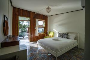 a bedroom with a bed and a desk and a window at คลองมาดโฮสเทลเกาะกูด Klongmad Hostel Kohkood 