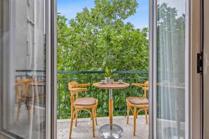 a patio with a table and chairs outside a sliding glass door at SALV3R Hotel in Athens
