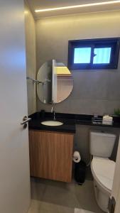 ein Badezimmer mit Waschbecken, Toilette und Spiegel in der Unterkunft Nawa Beach Residence by La Playa in Tamandaré
