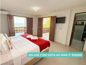 クムブコにあるPousada Sunrise Beachのベッドがあり海が見える寝室