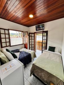 une chambre avec deux lits et un canapé dans l'établissement POUSADA GIRASSOL, à Santo Antônio do Pinhal