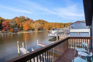 a balcony of a house with a boat in the water at Riverside Suites - Unit B in Saugatuck