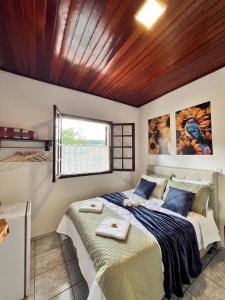 une chambre avec un grand lit avec une fenêtre dans l'établissement POUSADA GIRASSOL, à Santo Antônio do Pinhal