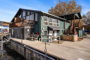 a green house on a dock next to the water at Riverside Suites - Unit A in Saugatuck