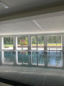 una gran piscina en una habitación grande con ventanas en Maison Poluc - Cadeau des Alpes, en Champoluc