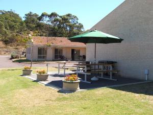 a patio area with a table, chairs, and umbrella at Harbourside Motel in Albany