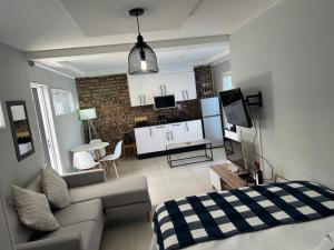 a living room with a couch and a kitchen at Home Away From Home 6 minutes away from beach in Cape Town