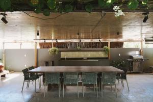 a large wooden table and chairs in a room at Casa com piscina aquecida, cozinheira, 30m do mar in Barra do Camaragibe